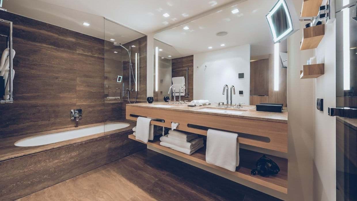 Bathroom with dual vanity, soaking tub, and rainfall shower head