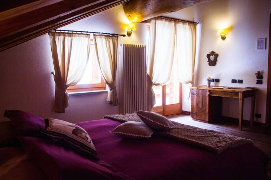 Bedroom with sloped wooden ceiling and writing desk