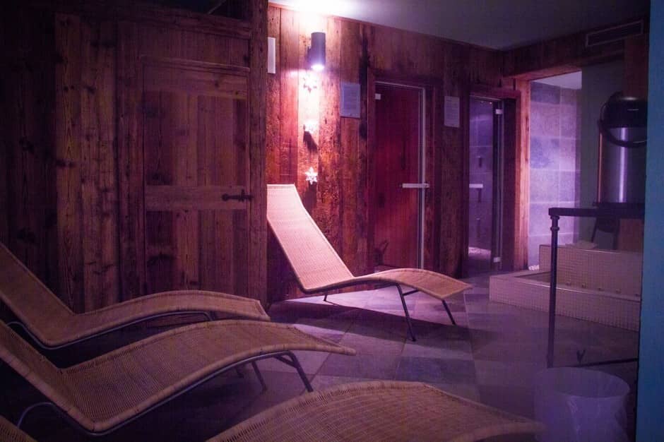 Wellness area featuring sauna and tiled foot bath; seating for three