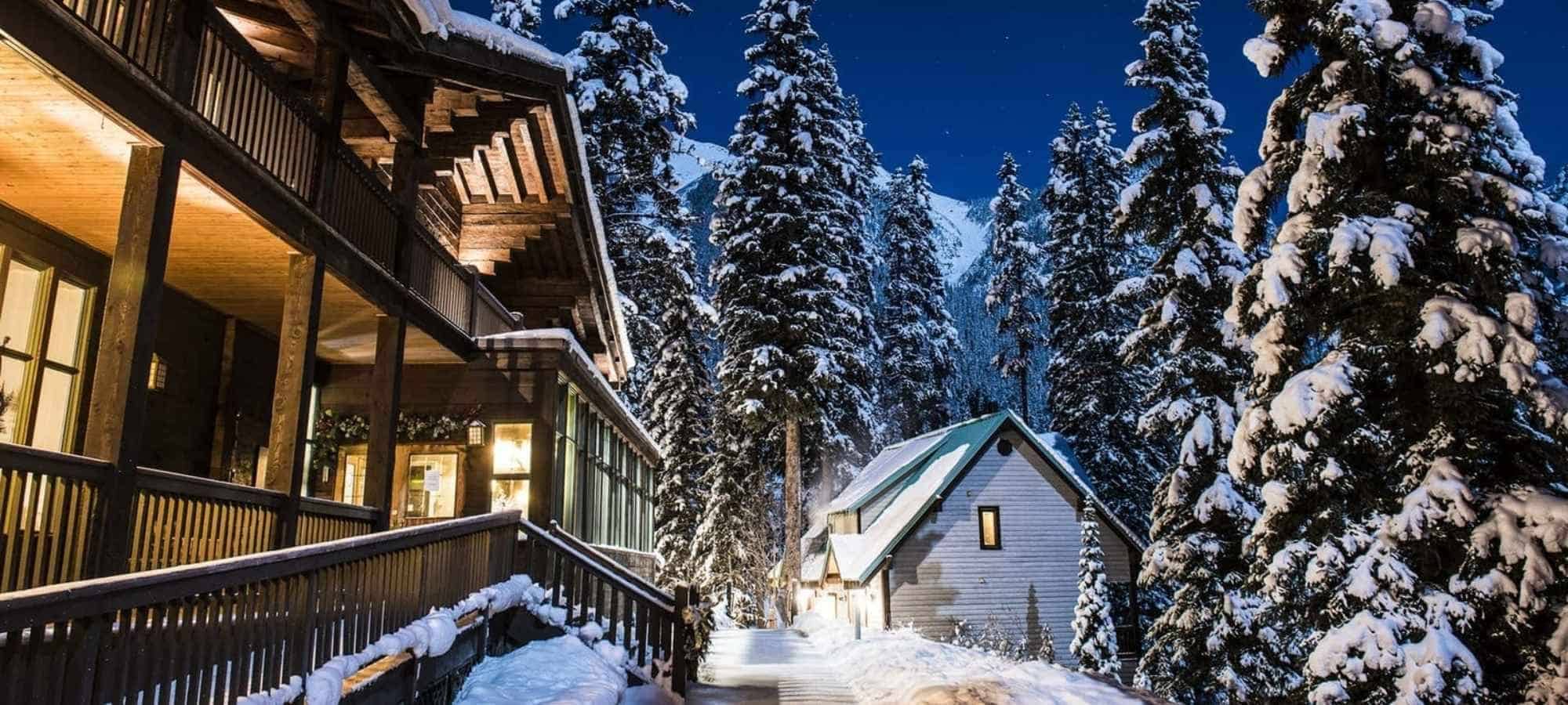 Timber lodge exterior with multi-level balconies and snowy mountain backdrop