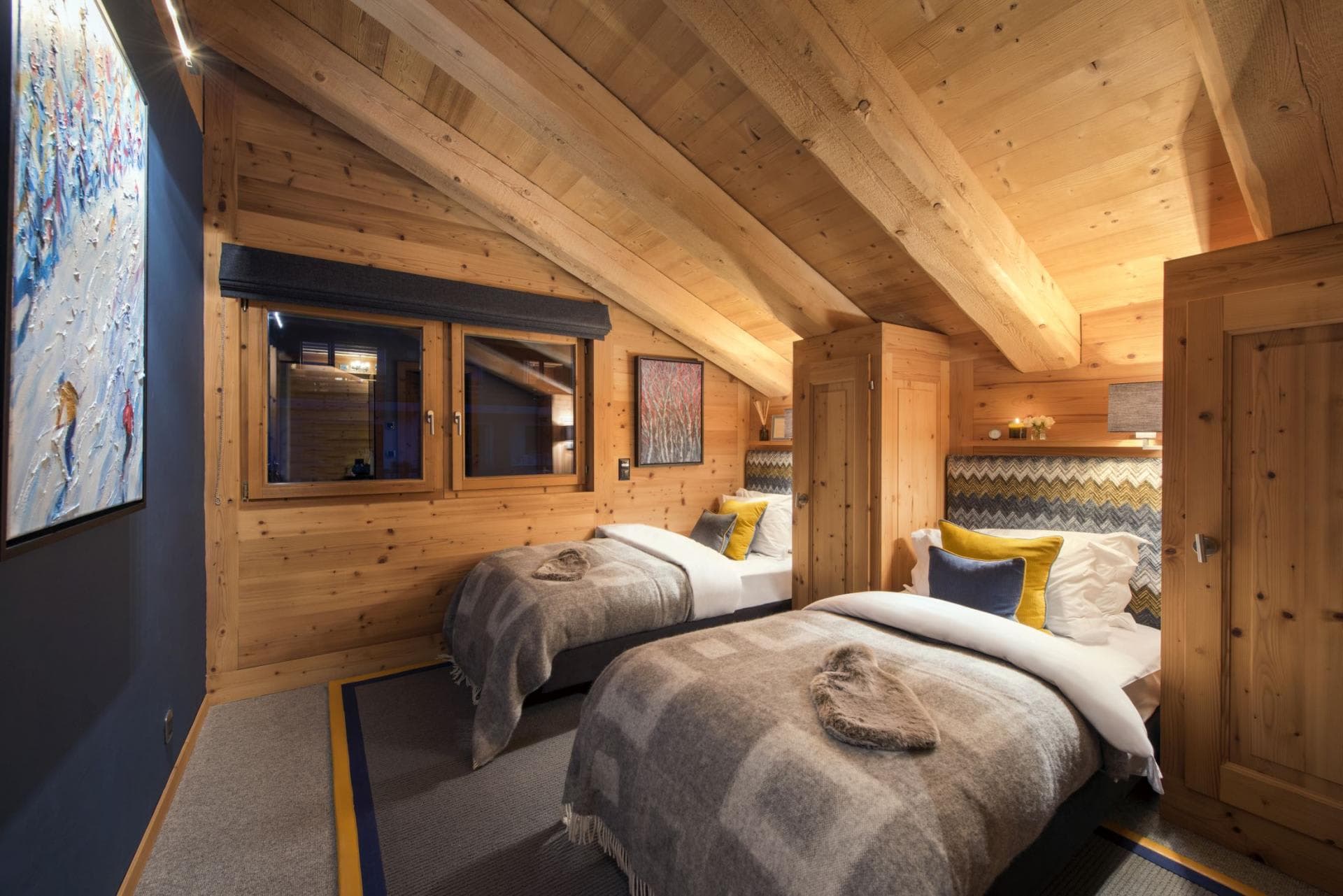 Guest bedroom with two twin beds and vaulted timber ceilings