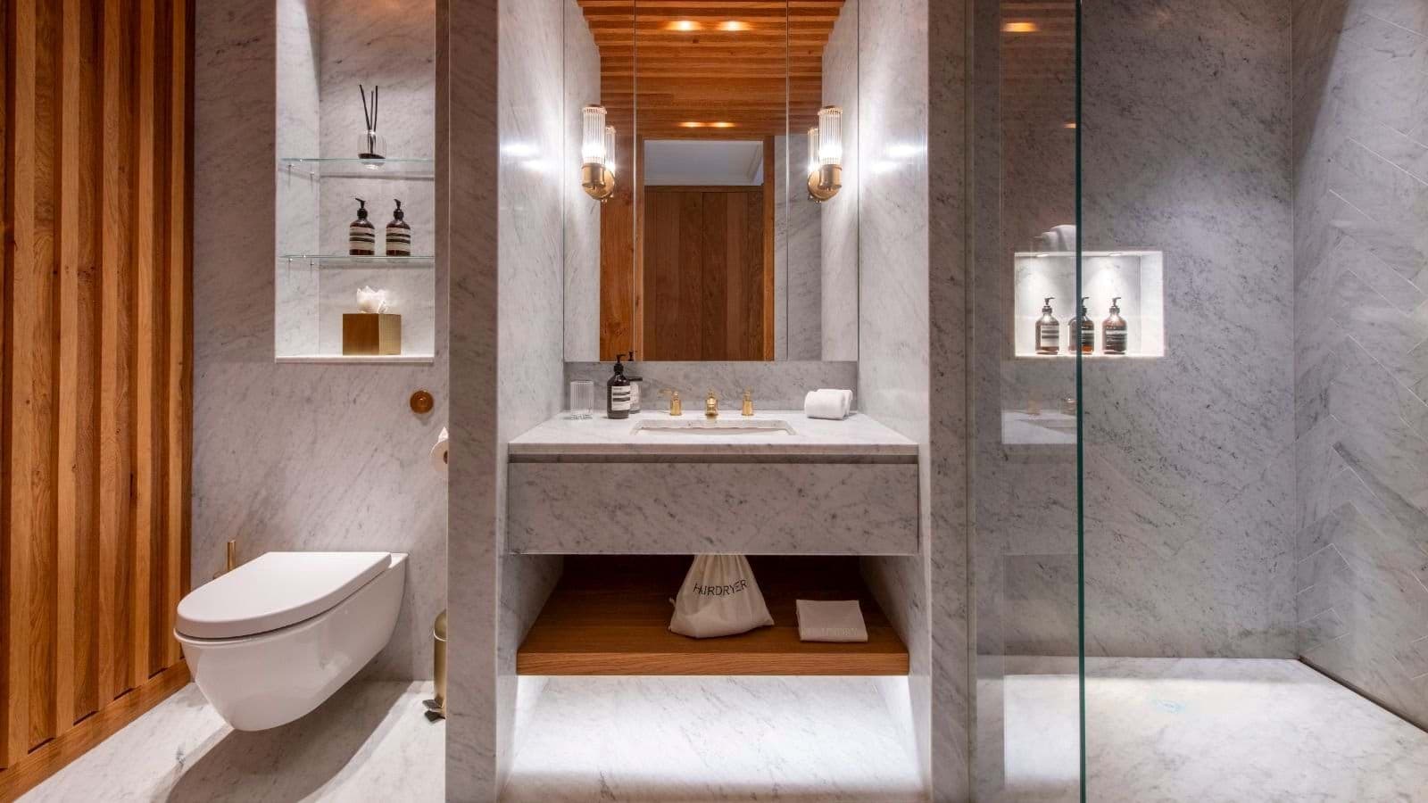 Marble bathroom with walk-in shower and brass fixtures