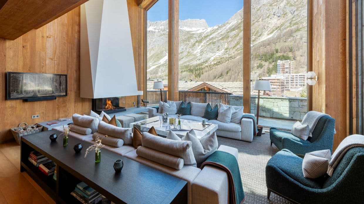 Living room with sectional seating and floor-to-ceiling mountain views
