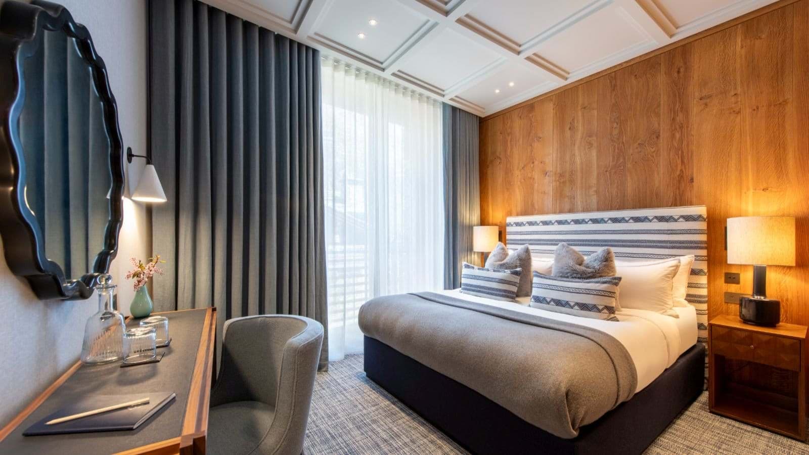 Guest bedroom with king bed, desk area, and blackout curtains