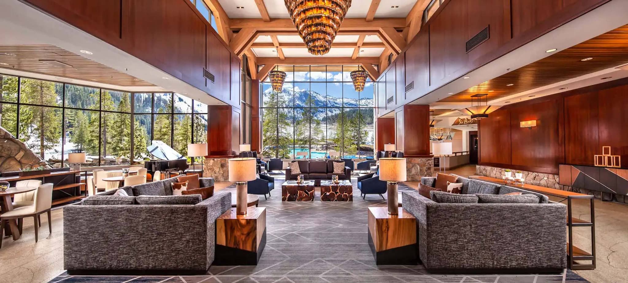 Lobby lounge with grand piano and floor-to-ceiling mountain views