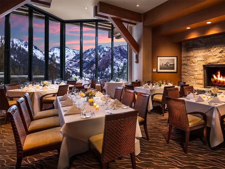 Dining room with wood-burning fireplace and floor-to-ceiling mountain views