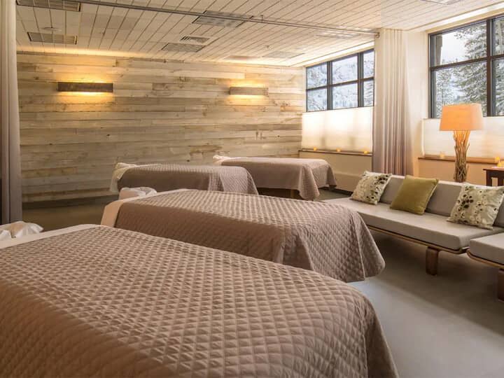 Spa treatment room with four massage tables and lounge seating