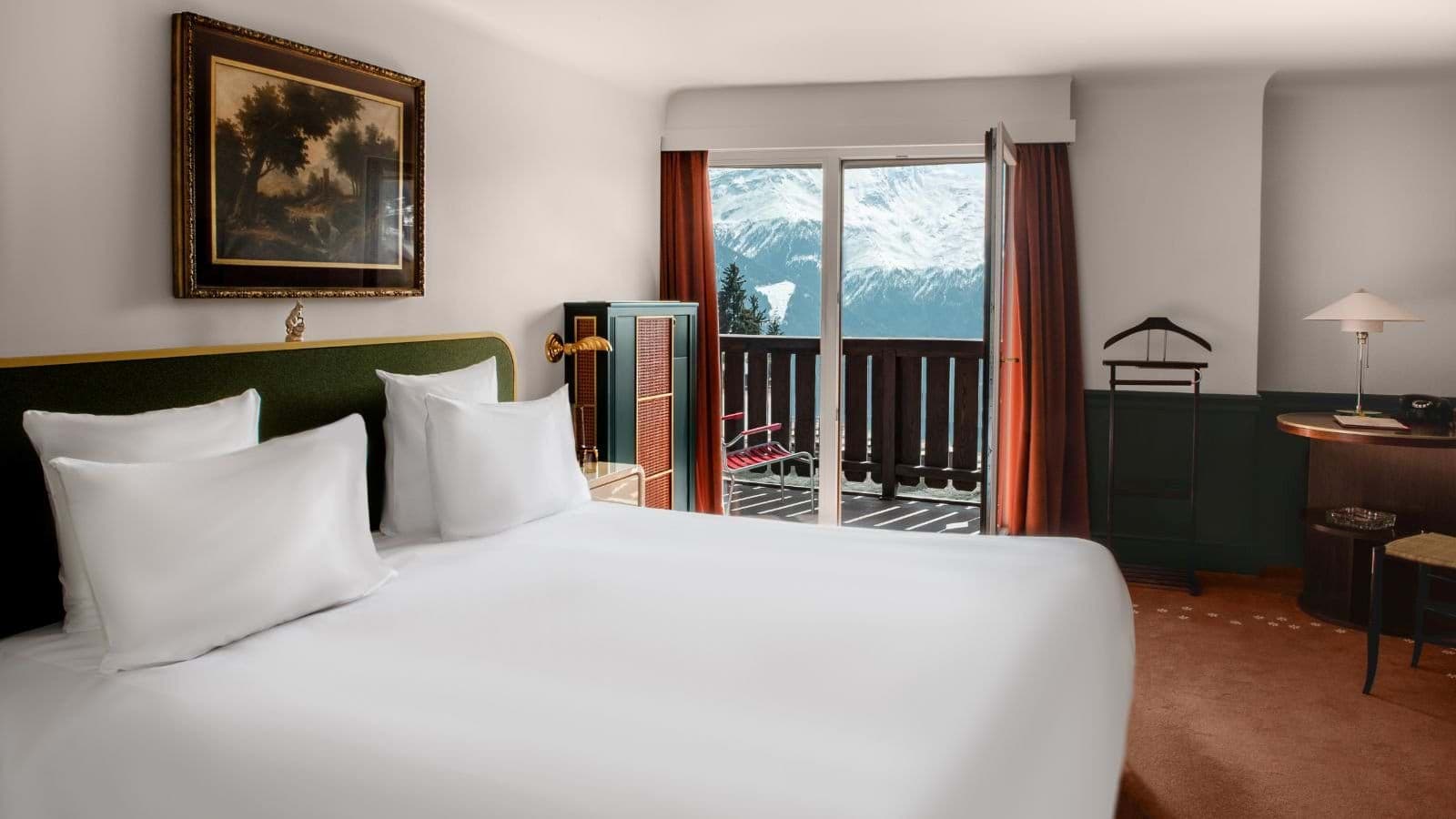 Primary bedroom with king bed and private balcony mountain views