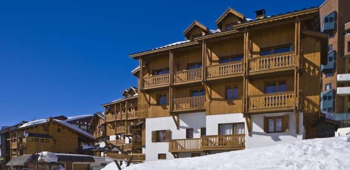 Chalet-style exterior with private balconies and direct slope access