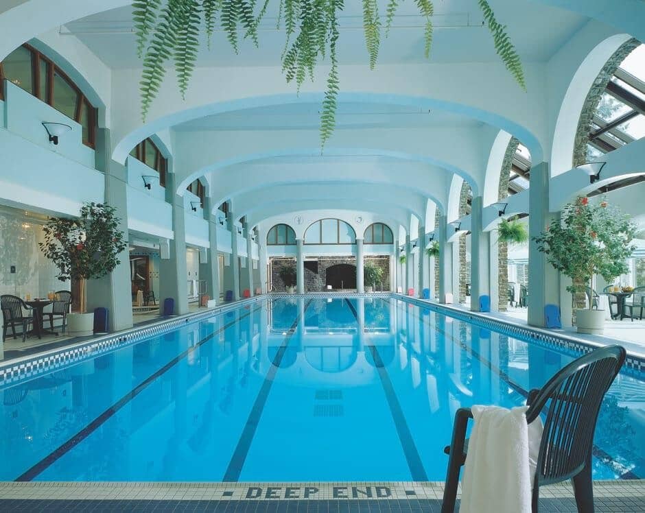 Indoor lap pool with vaulted ceilings and poolside seating