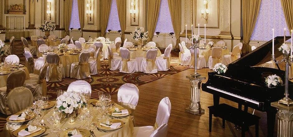 Grand ballroom event space with baby grand piano and parquet dance floor