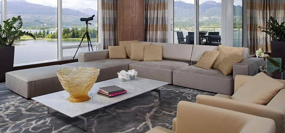 Living area with sectional seating and harbor views via floor-to-ceiling windows