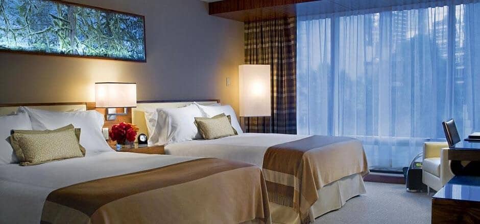 Guest bedroom with two queen beds and floor-to-ceiling city views