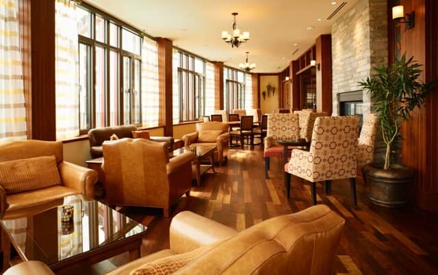 Shared lounge with stone fireplace and floor-to-ceiling windows