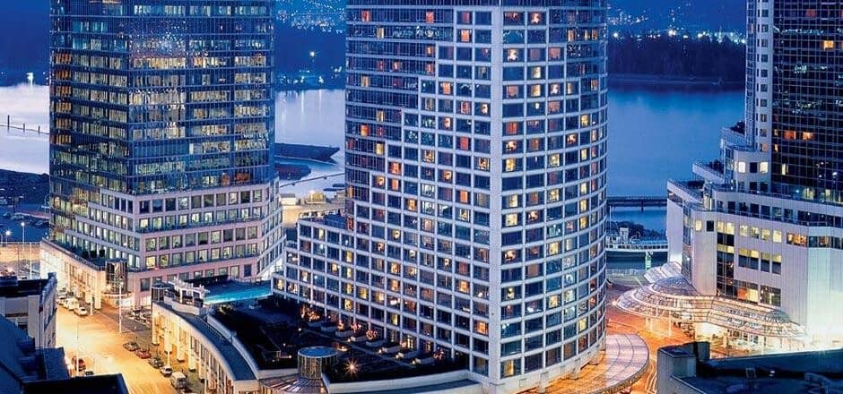 Waterfront high-rise exterior with views of the harbor and city lights
