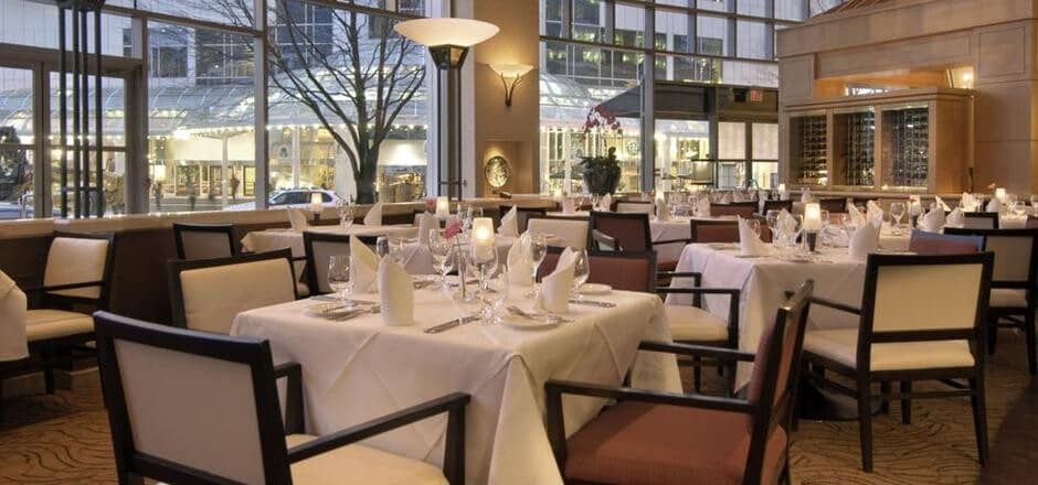Formal dining room with wine storage and floor-to-ceiling city views