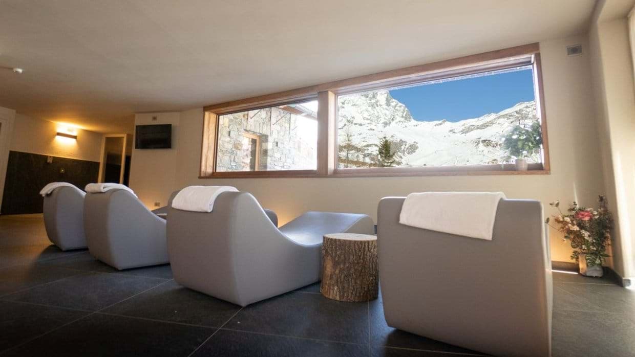 Spa relaxation room with heated loungers and Matterhorn mountain views