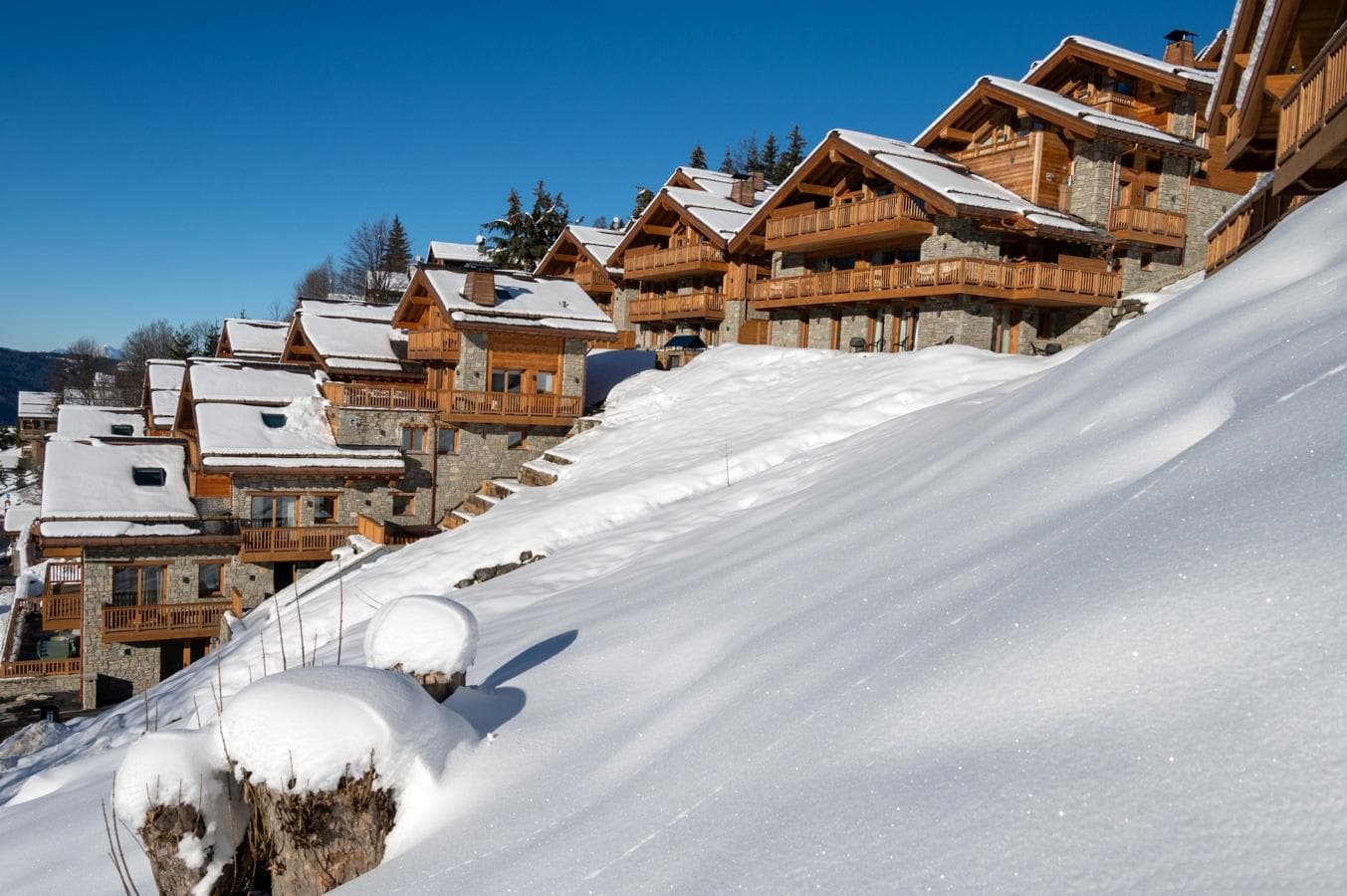 Slope-side chalets with private balconies and stone exteriors
