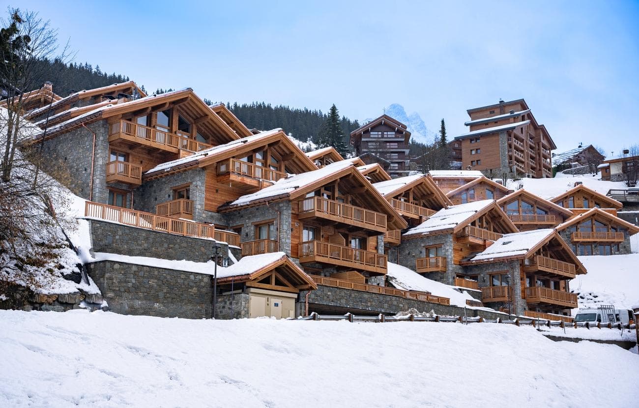 Ski-in/ski-out chalet exterior with stone masonry and private balconies