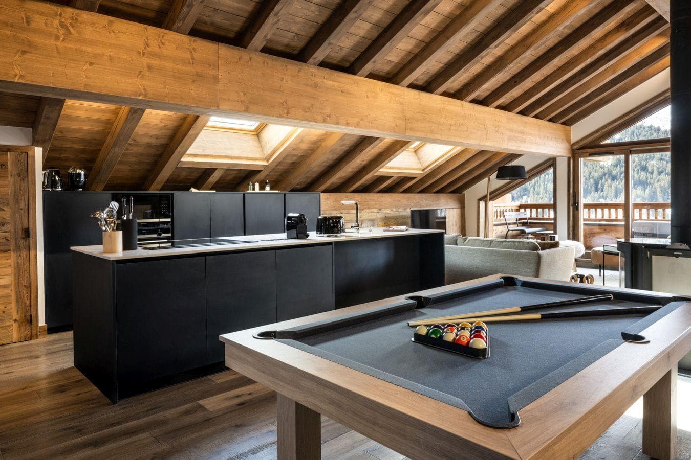 Open-plan kitchen and living area with pool table and mountain-view balcony