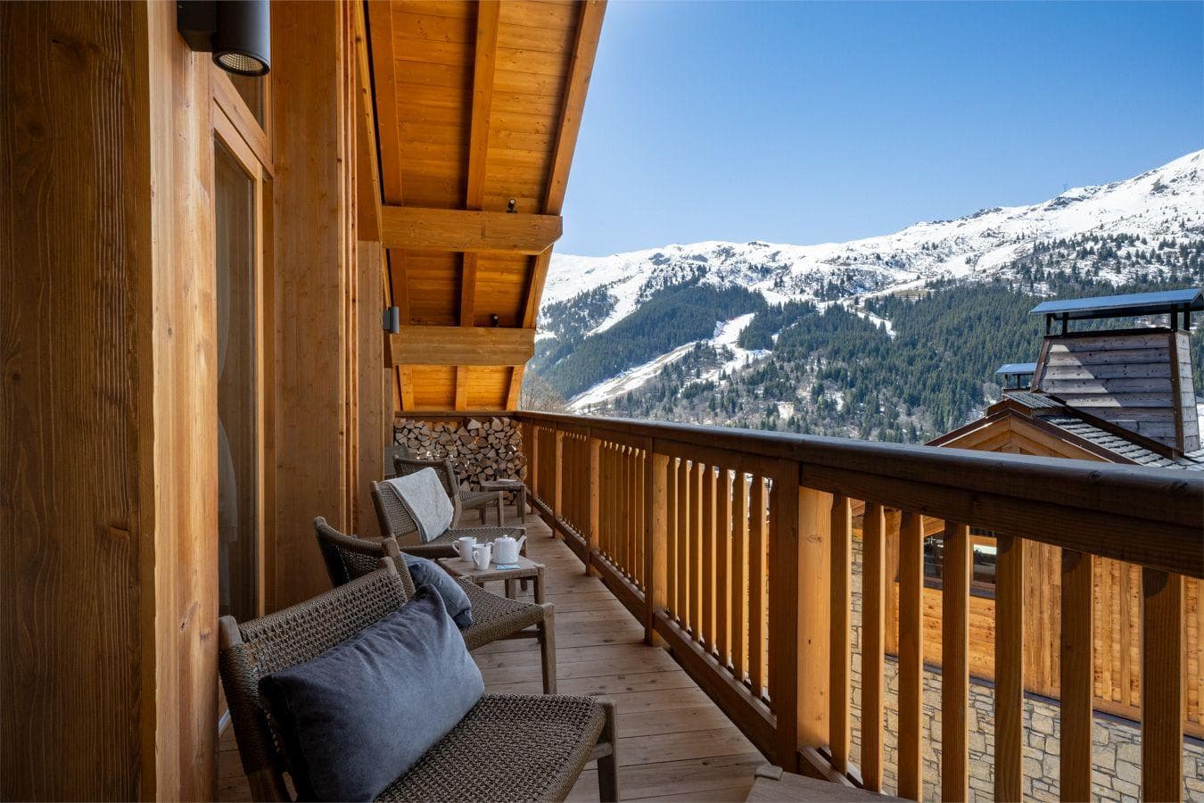 Covered timber balcony with lounge seating and panoramic alpine views