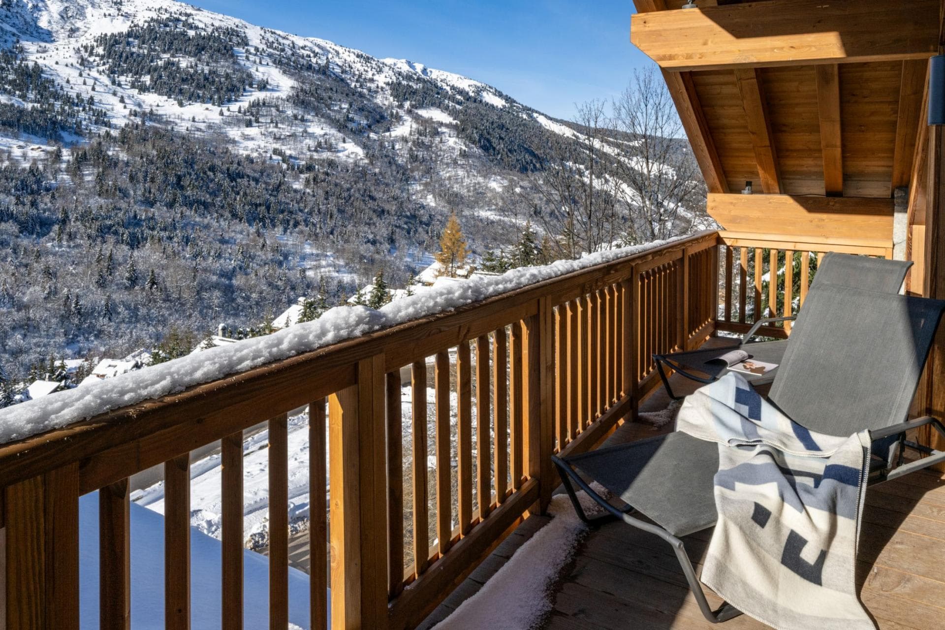 Balcony with dual lounge chairs and mountain valley views
