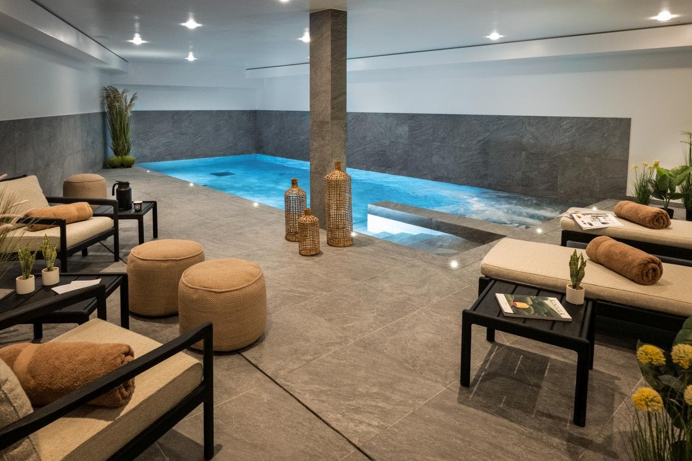Indoor pool with integrated whirlpool jets and lounge seating area