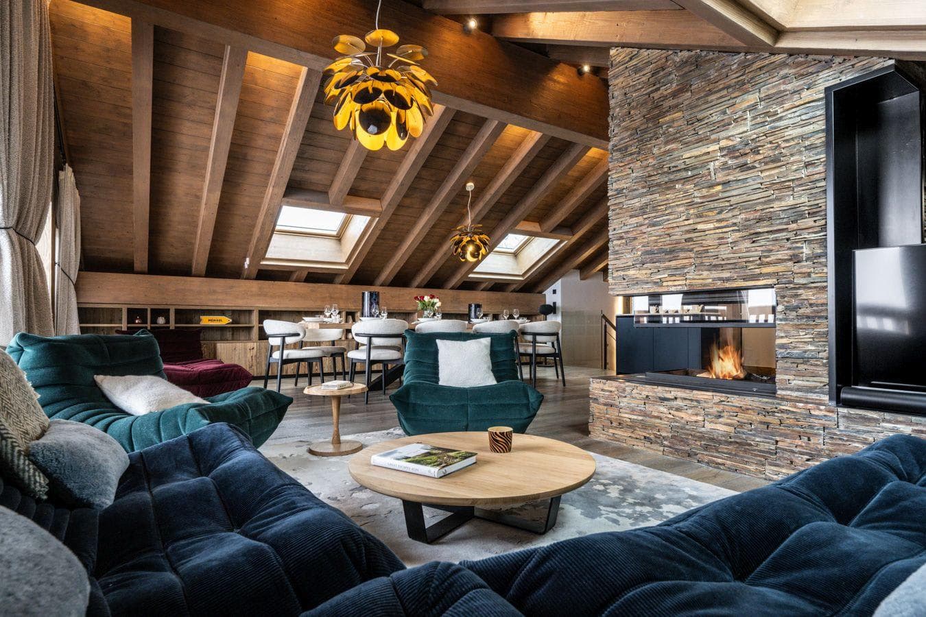 Living area with stone fireplace and vaulted wood ceilings with skylights