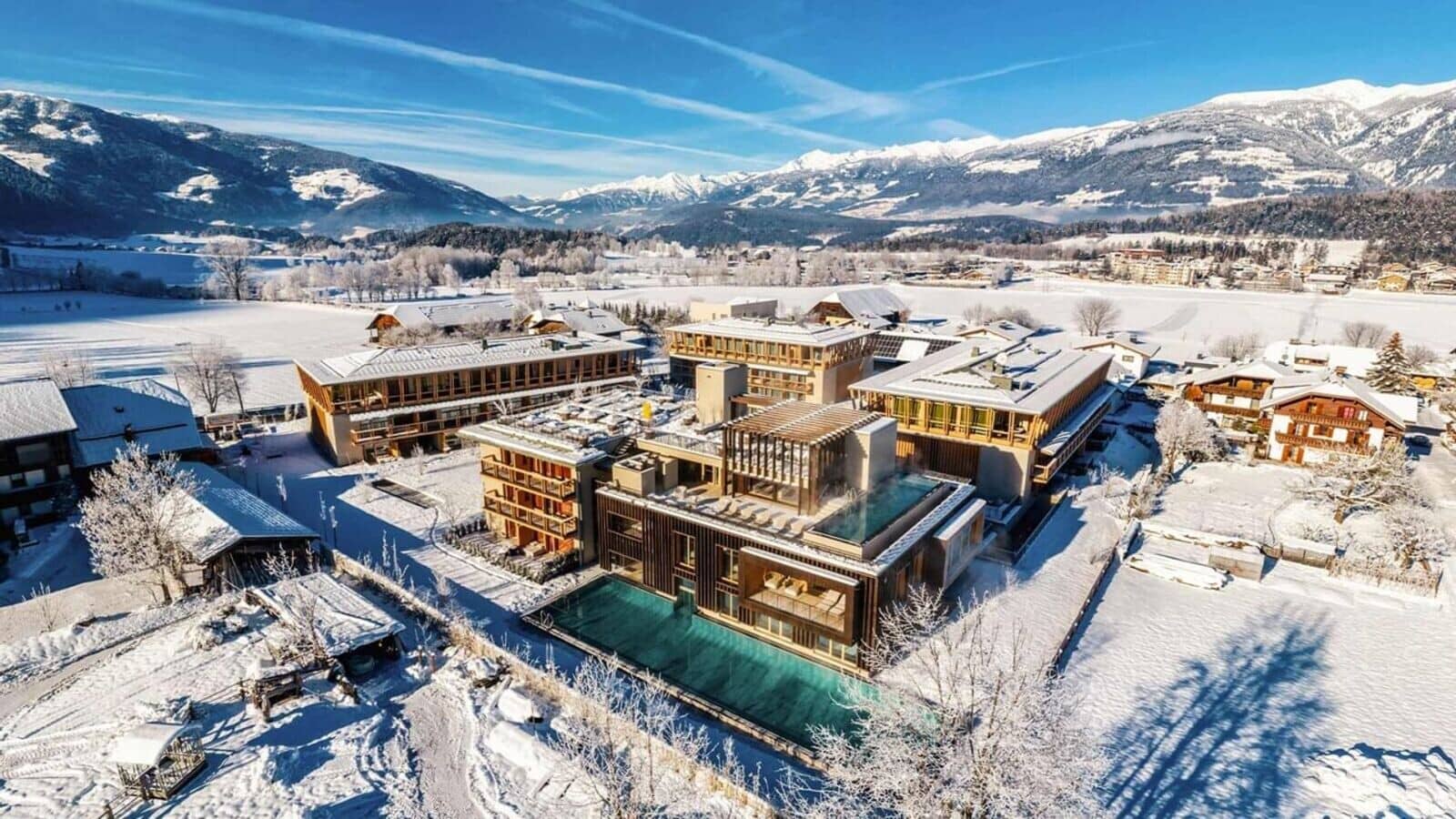 Aerial view of resort with heated outdoor lap pool and mountain backdrop