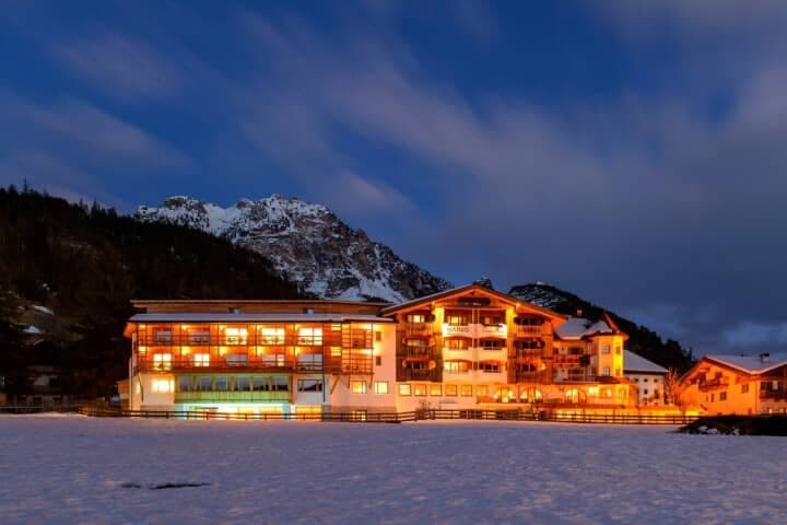 Chalet exterior at dusk with private balconies and mountain backdrop