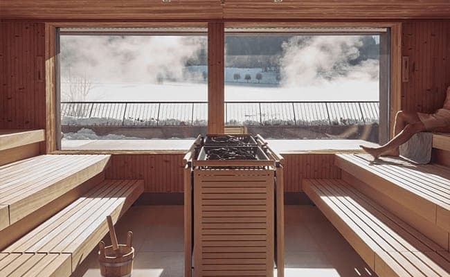 Cedar sauna with tiered seating and panoramic snow-covered valley views