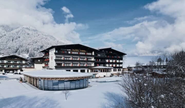 Hotel exterior featuring private balconies and snow-covered mountain backdrop