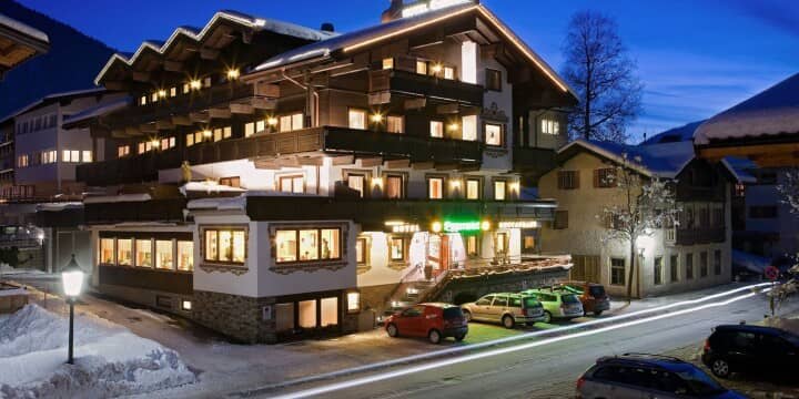 Chalet exterior at dusk with private balconies and on-site parking