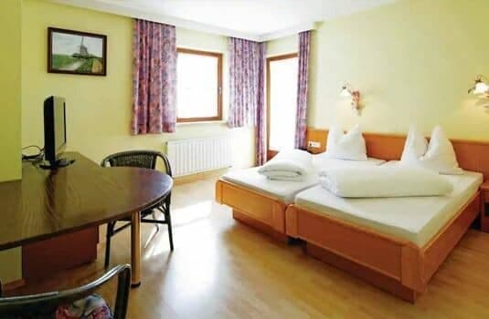 Guest bedroom with two twin beds and dedicated workspace with desk