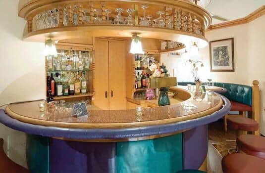 Circular wet bar with integrated glassware storage and stool seating