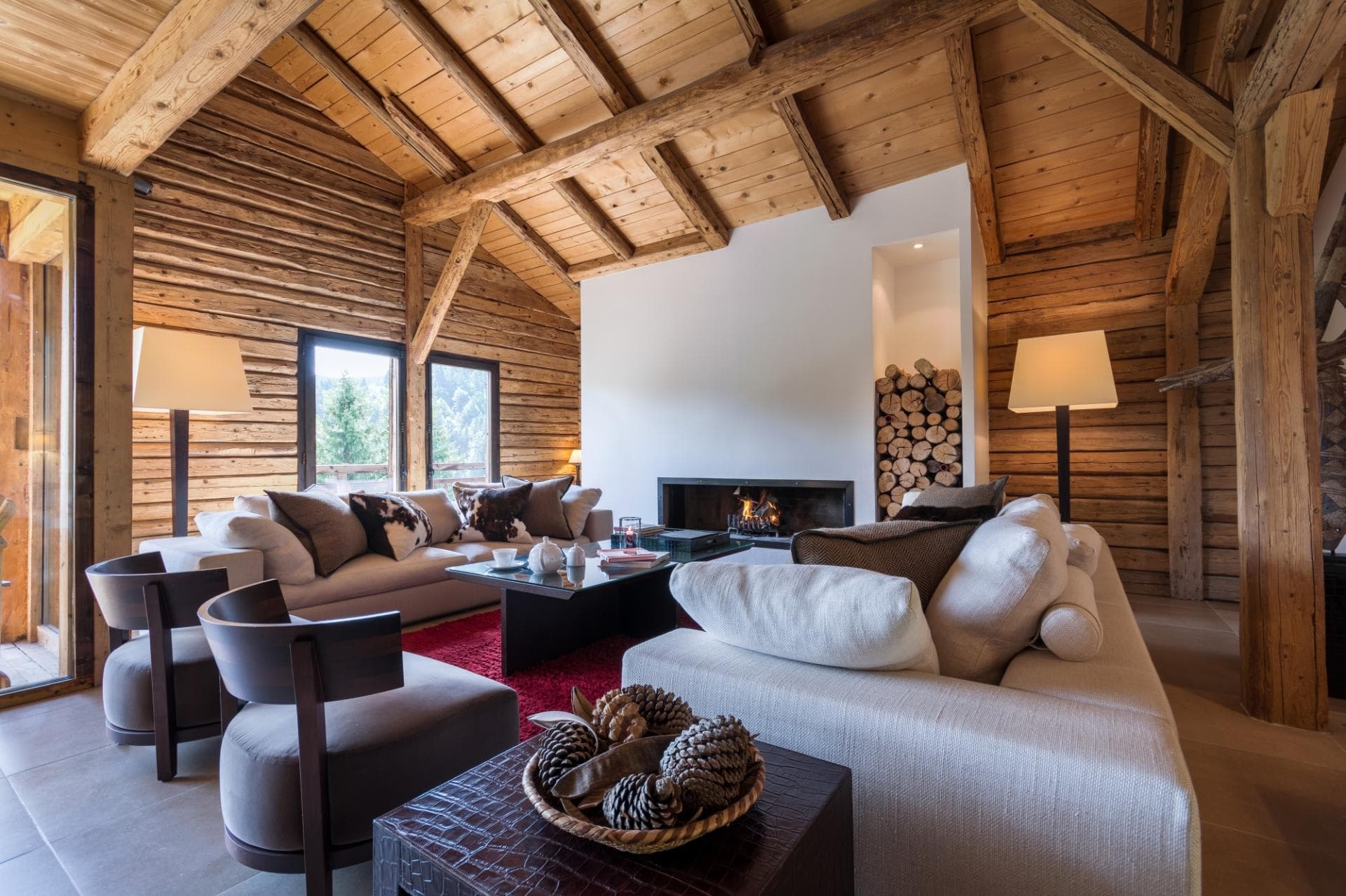 Living area with wood-burning fireplace and floor-to-ceiling log walls