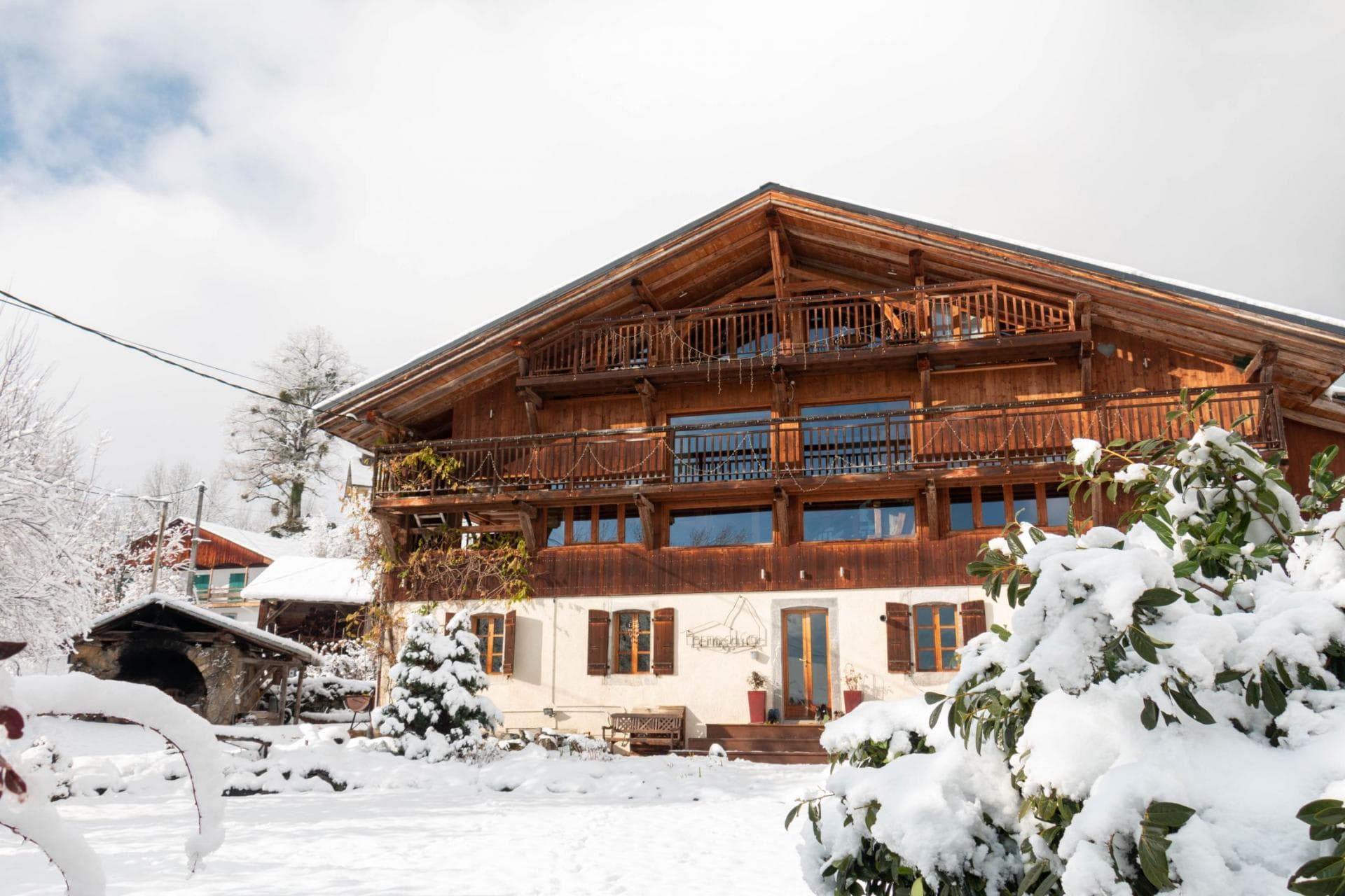 Multi-level wooden chalet with wrap-around balconies and snowy yard