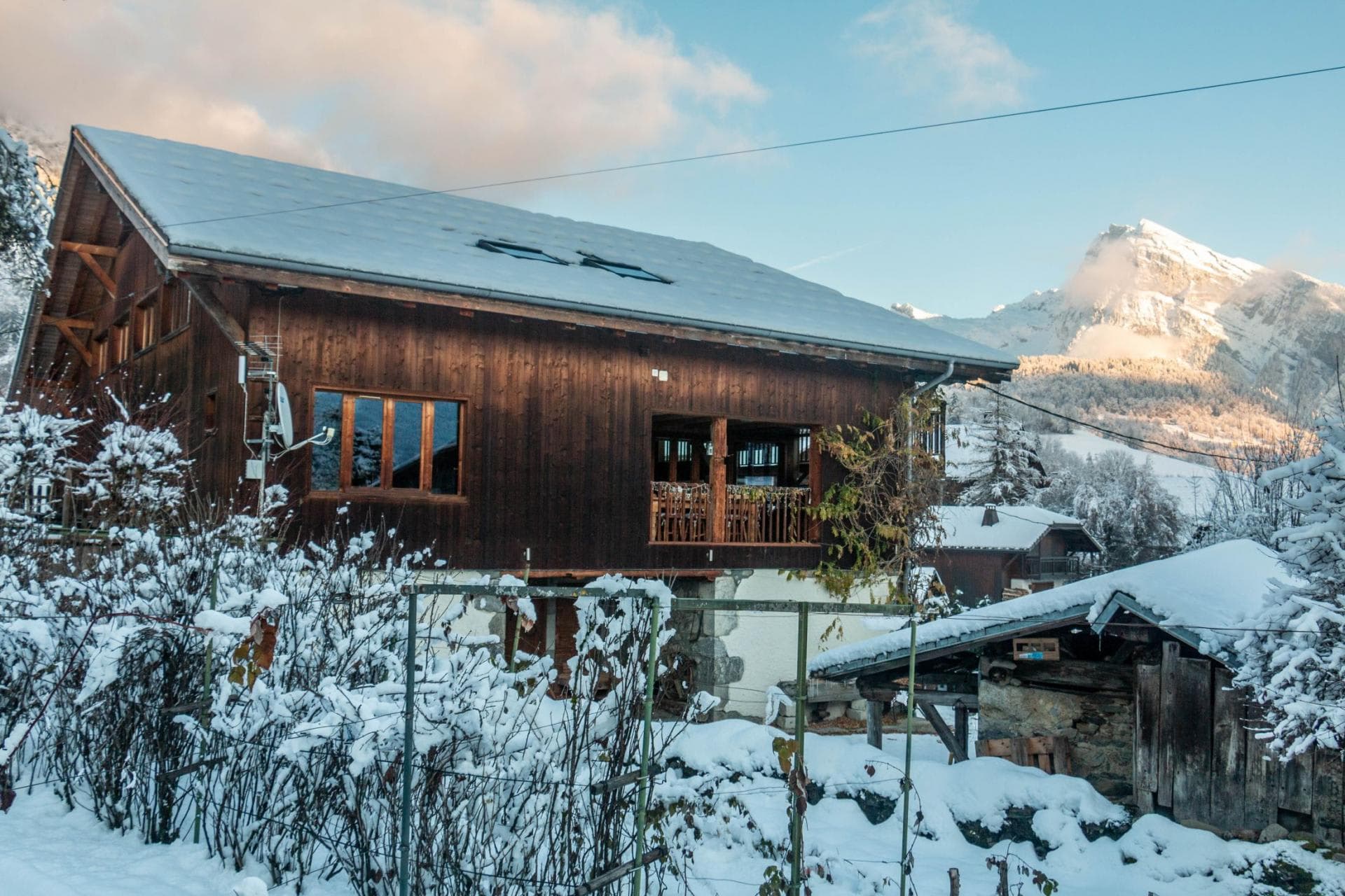 Chalet exterior with covered balcony and mountain peak views