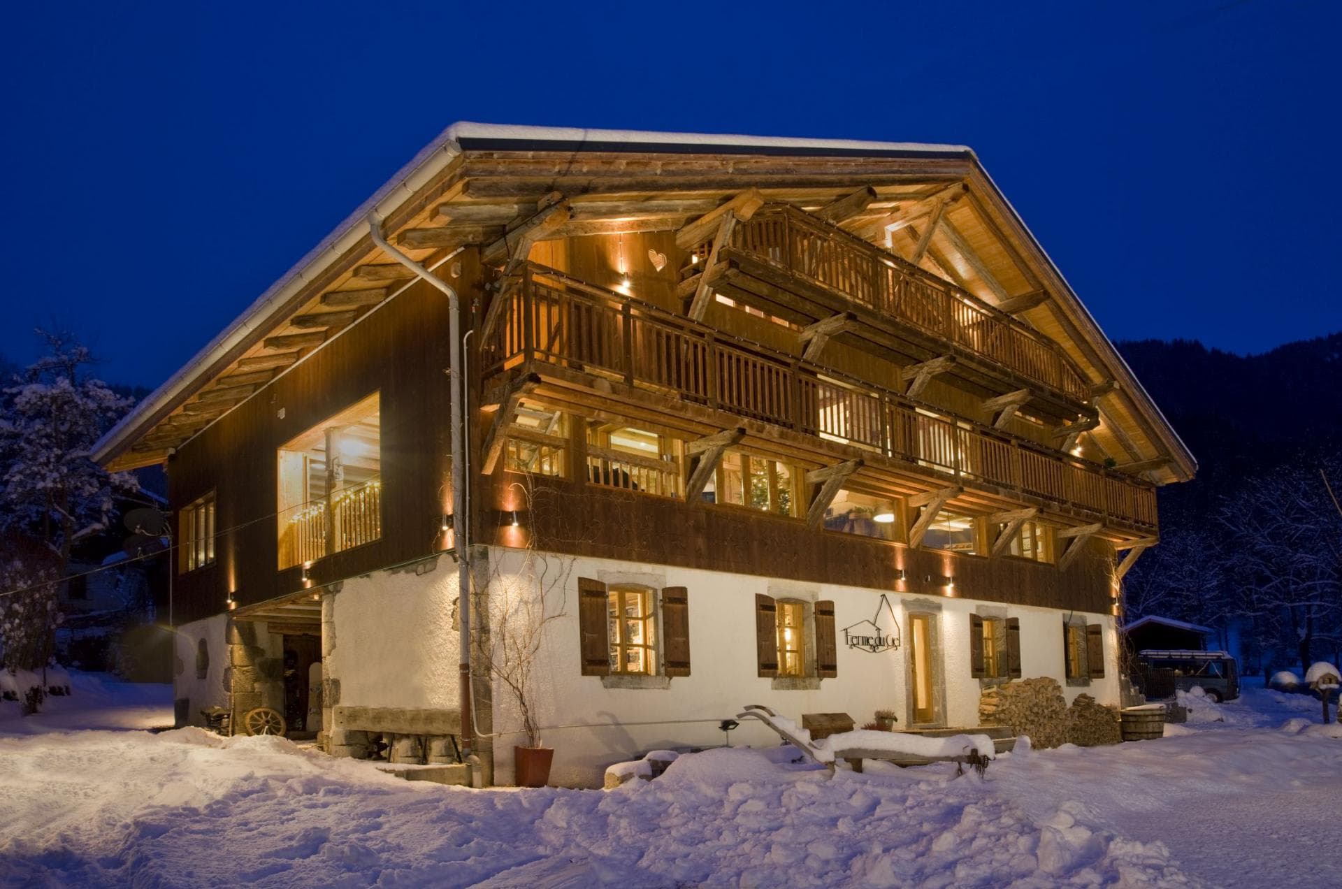 Three-story mountain chalet with multiple balconies and snow-covered grounds
