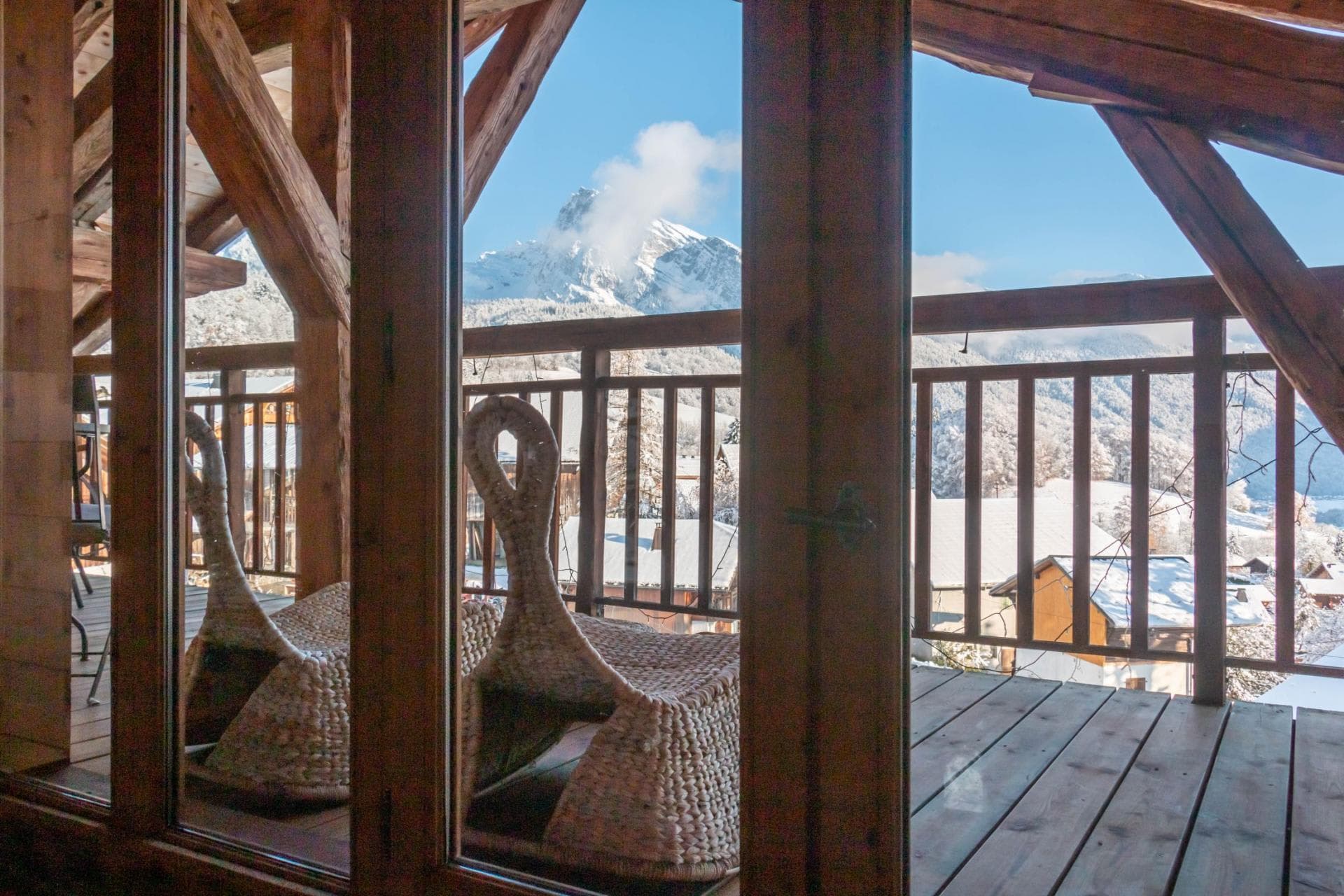 Private balcony with woven seating and mountain peak views