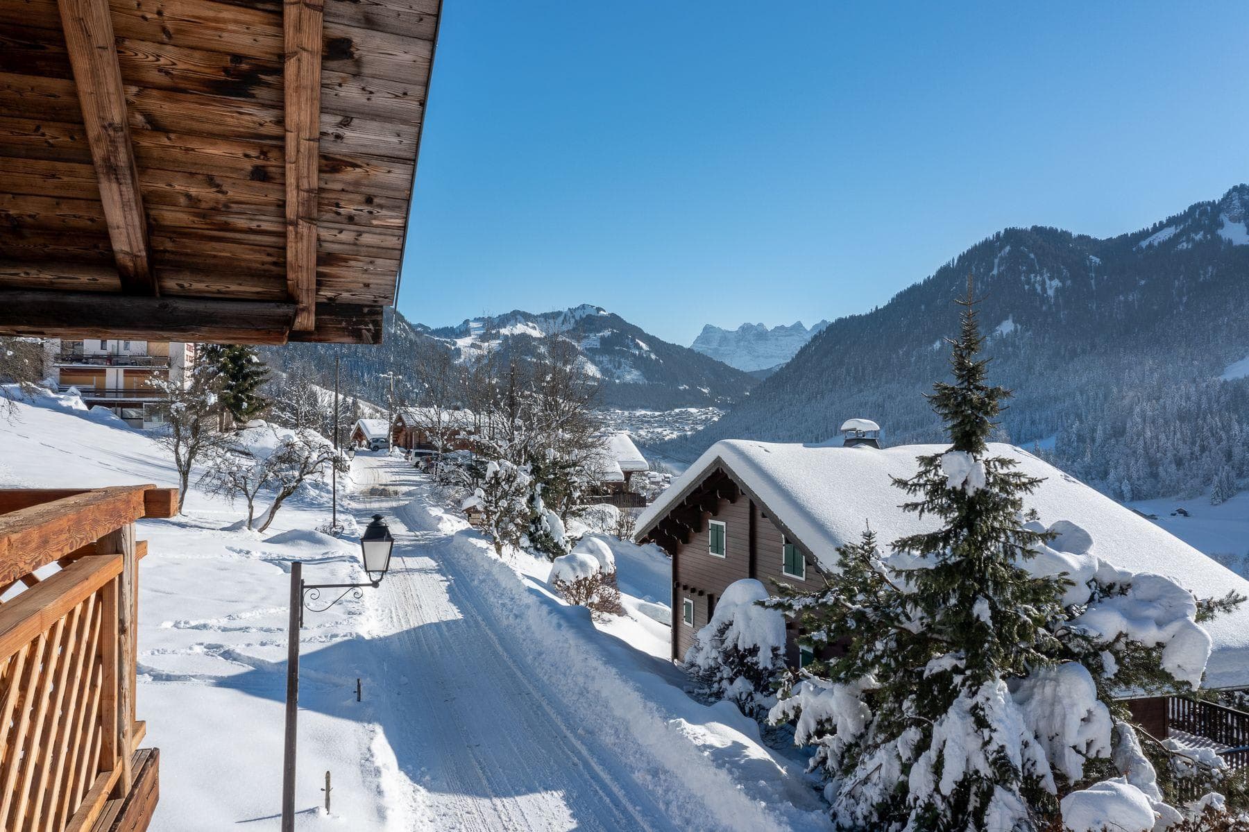 Private balcony view overlooking snow-covered alpine village and Dents du Midi peaks