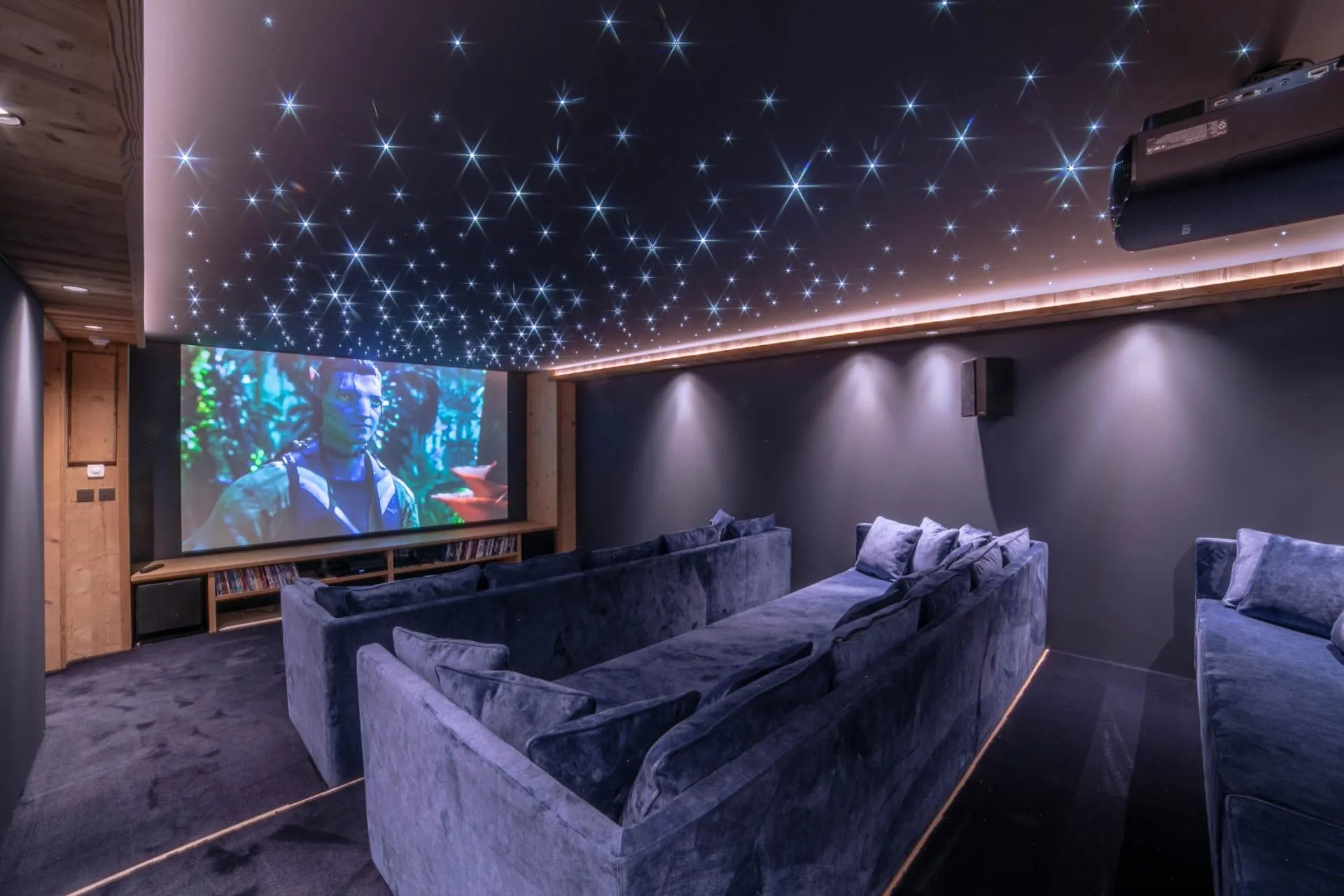 Private cinema with tiered sofa seating and a starlight ceiling