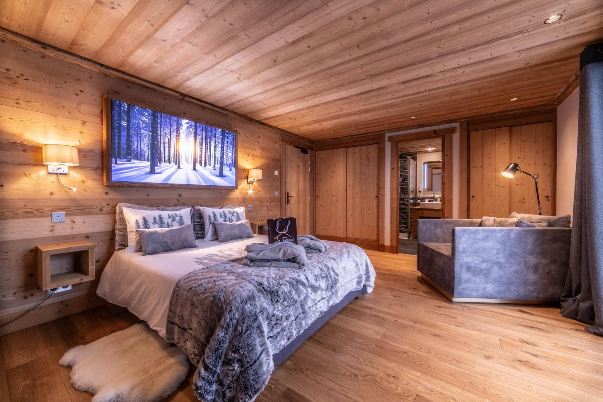 Wood-paneled bedroom with king bed and ensuite bathroom