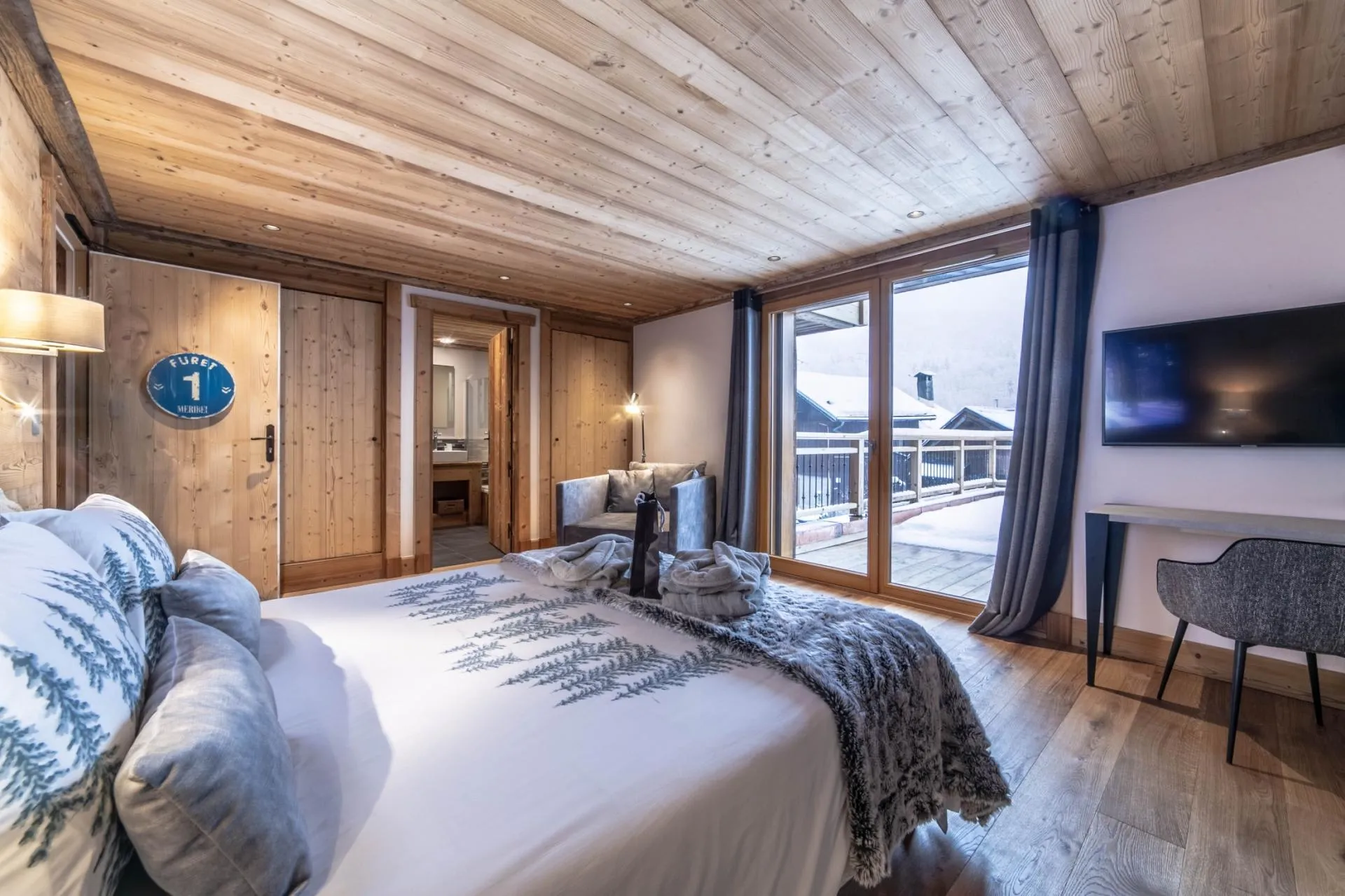 Double bedroom with balcony access, television and seating