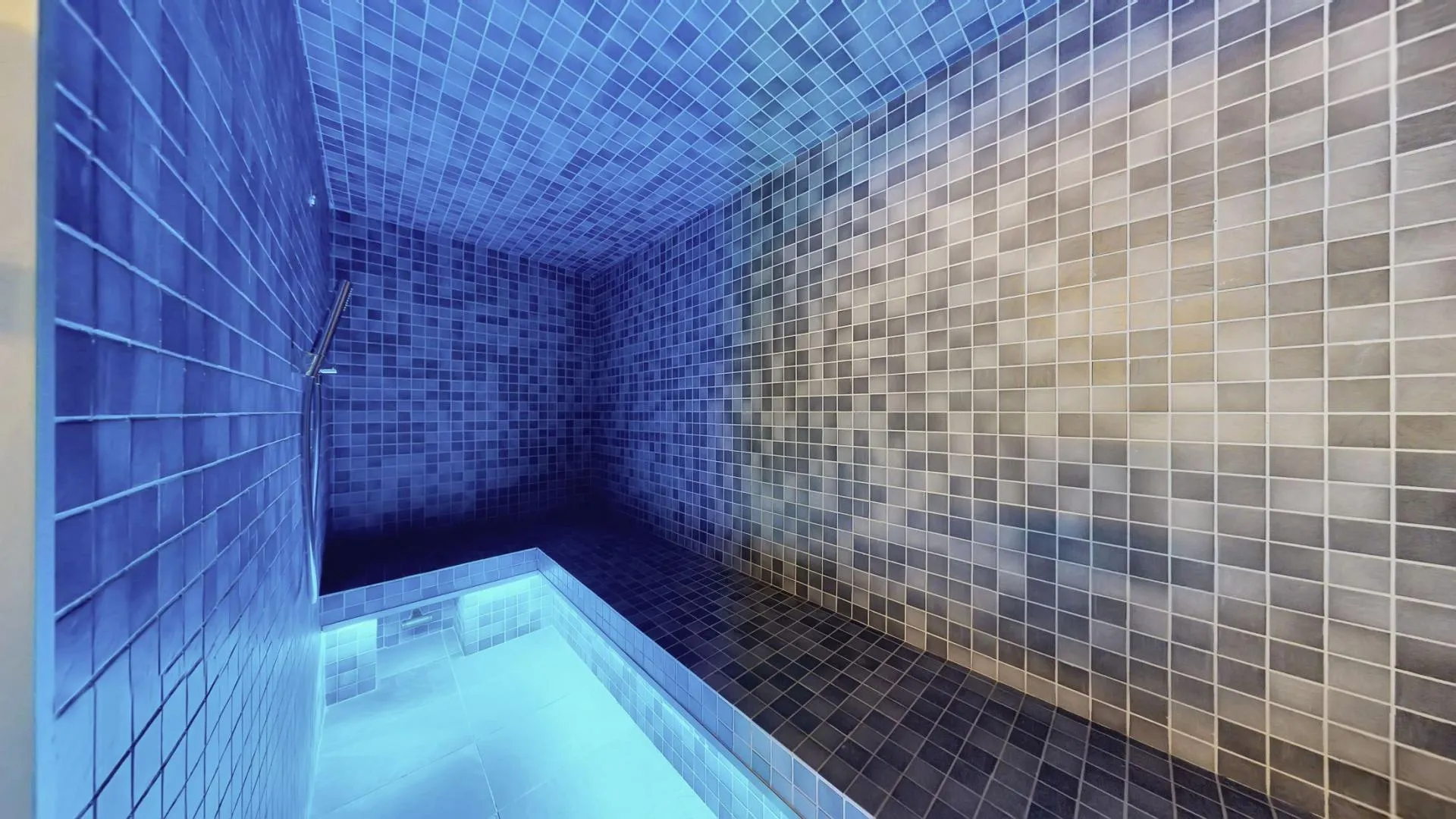 Mosaic-tiled hammam with built-in bench seating