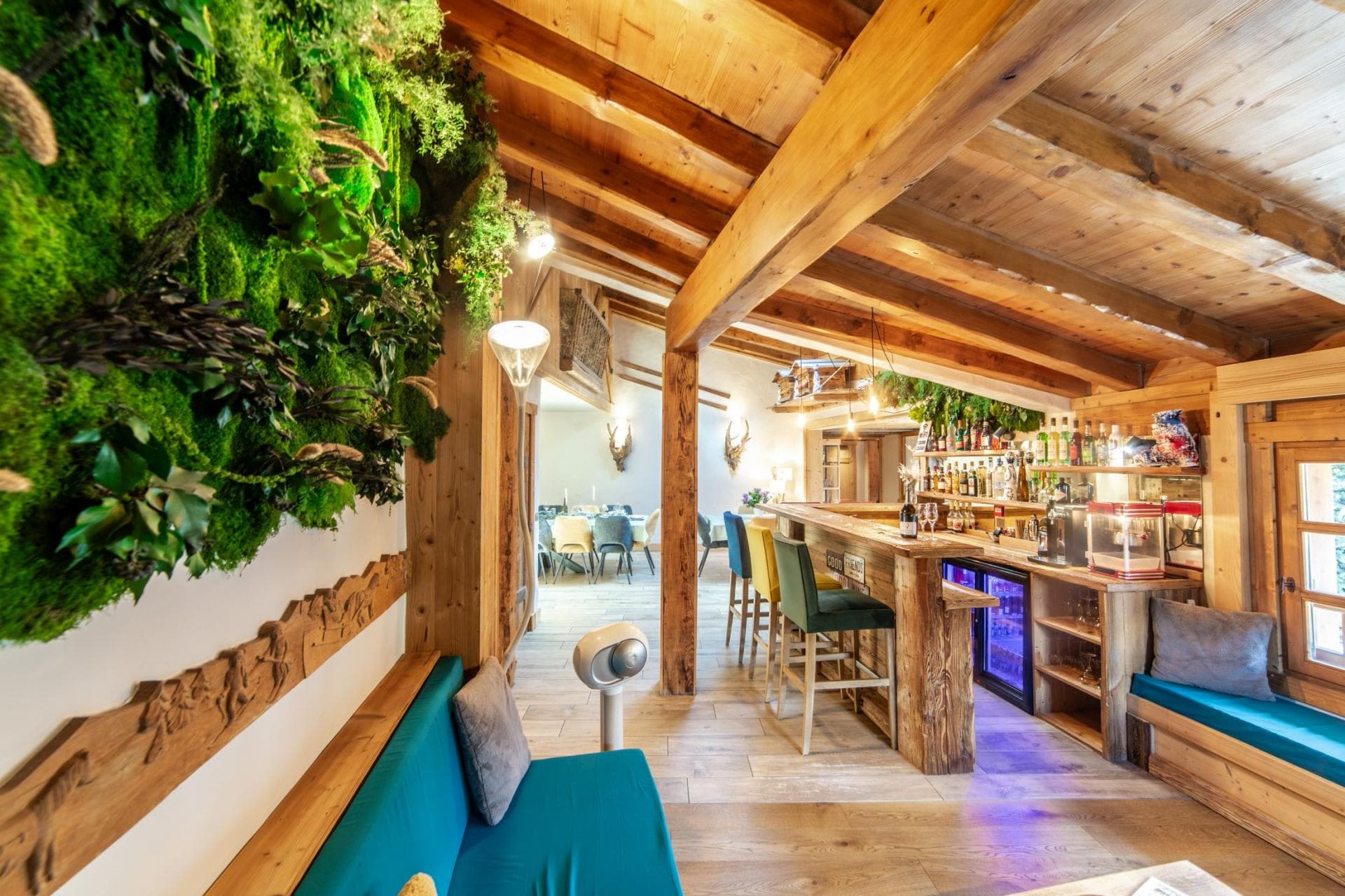 Private bar with beverage fridge, counter seating, and living moss wall