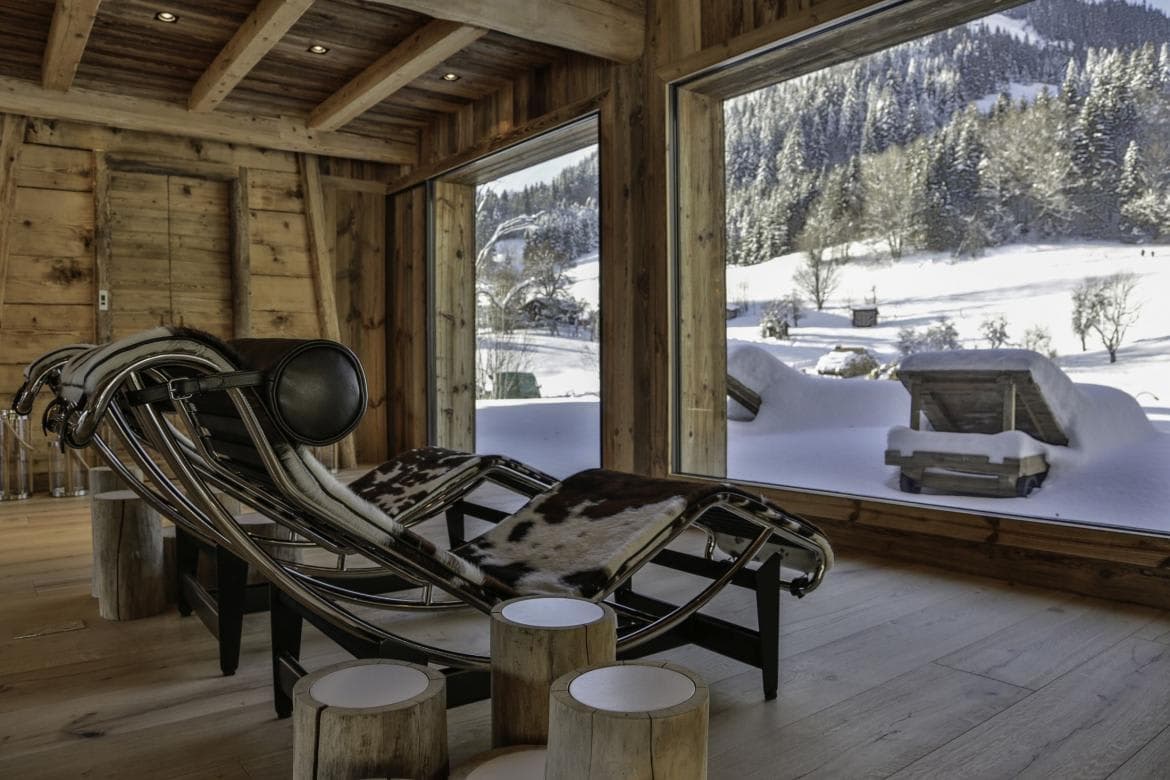 Spa lounge with cowhide chaises and floor-to-ceiling mountain views