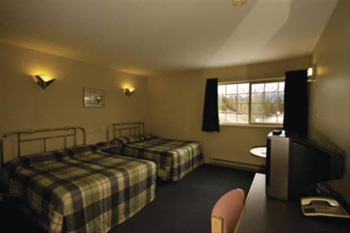 Guest bedroom with two queen beds and mountain views