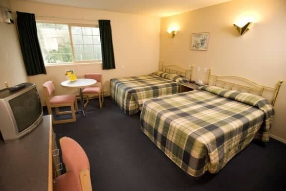 Guest bedroom with two queen beds and small dining table