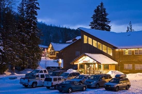 Ski-in lodge entrance with designated guest parking and lighted snow paths